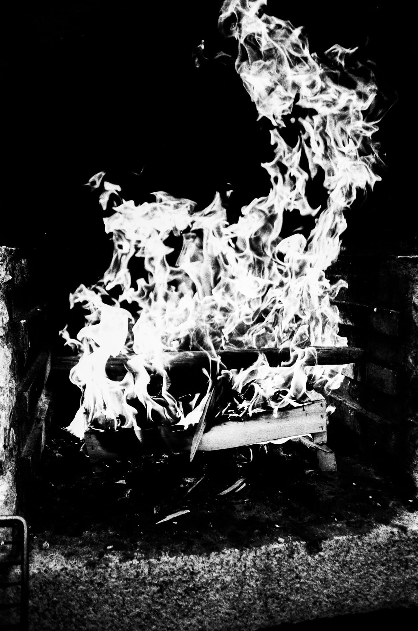 Feu de joie en flammes la nuit, photographie argentique noir et blanc grand contraste
