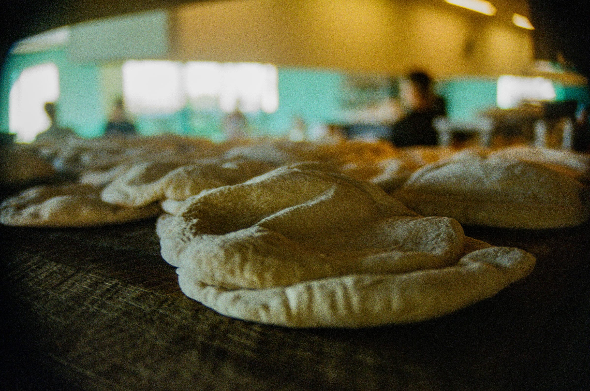 Pains pita frais dans une boulangerie avec faible profondeur de champ, photographie argentique couleur